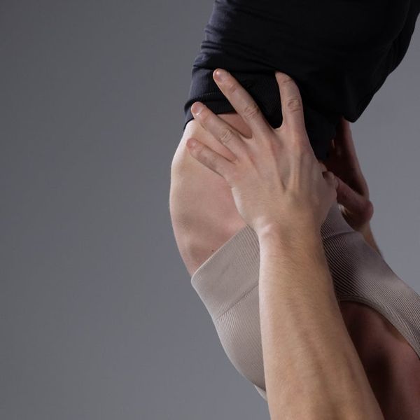 Man stretching with focus in a calm, minimalist room, symbolizing flexibility and peace of mind.